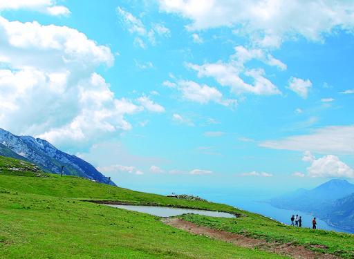 
 Escursionisti vicino a una pozza sul monte Baldo: spettacolare il panorama sul lago FOTO EUGENIO CIPRIANI 
