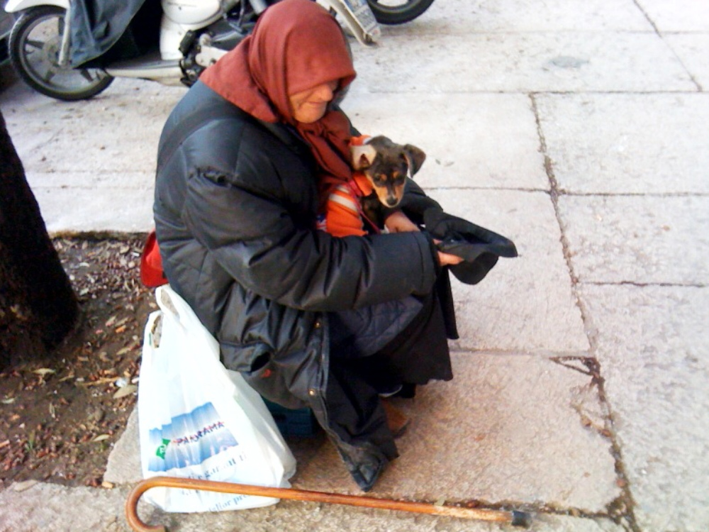 Mendicante con un cucciolo di cane