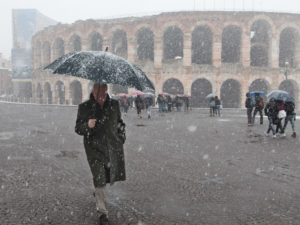 Un signore mentre passeggia in piazza Bra sotto l’abbondante nevicata «marzolina» FOTOSERVIZIO MARCHIORI 