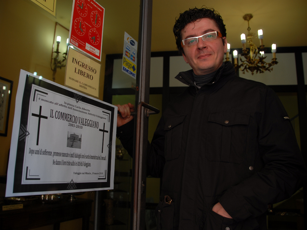 Luca Mastrodonato davanti alla sua attività commerciale e al cartello di lutto FOTO PECORA    