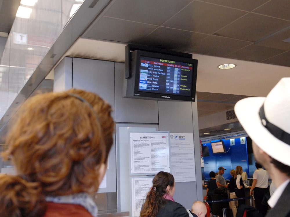 Passeggeri controllano le partenze in aeroporto
