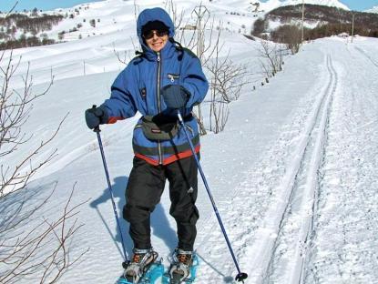 
 Un'escursionista con le ciaspole sul bordo di una pista per il fondo a San Giorgio 
