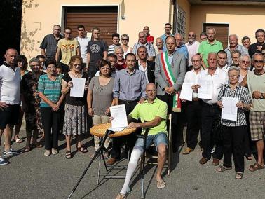 I residenti di Gargagnago davanti al loro ufficio postale che rischia di chiudere FOTOSERVIZIO AMATO